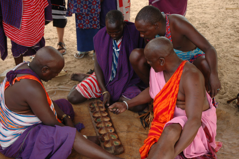 Men playing bao and talking about cows in Orbili