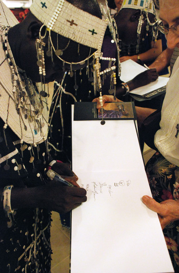 Martha proudly signing  her name in the "En-kata A Time For Singing" book