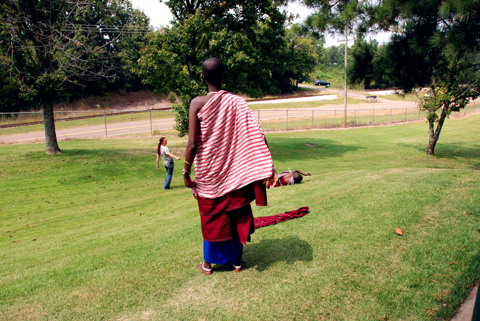 Sifa, Nadine and Mathayo rolling down the grassy hill, it's been a long car ride.